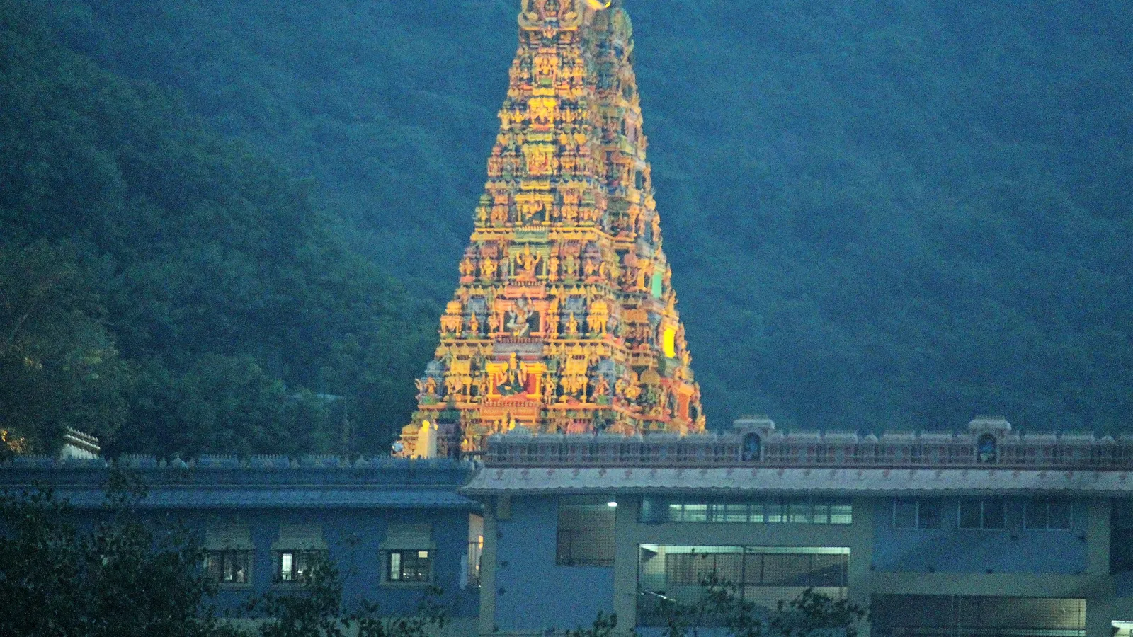 The illuminated gopuram of the Kanaka Durga temple on Indrakeeladri hill above the Krishna
