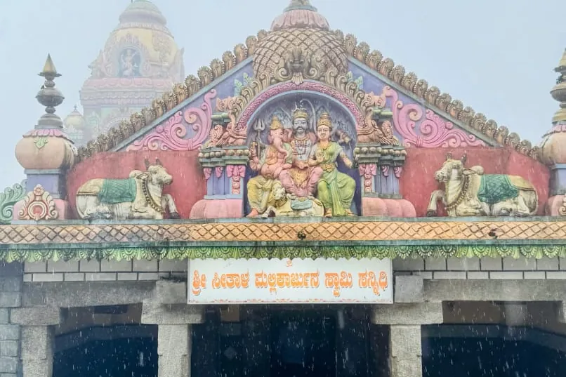 The painted pediment of the Seethala Mallikarjuna Swamy temple at Seethalayyanagiri, Shiva and Parvati flanked by Nandi figures, in rain and mist