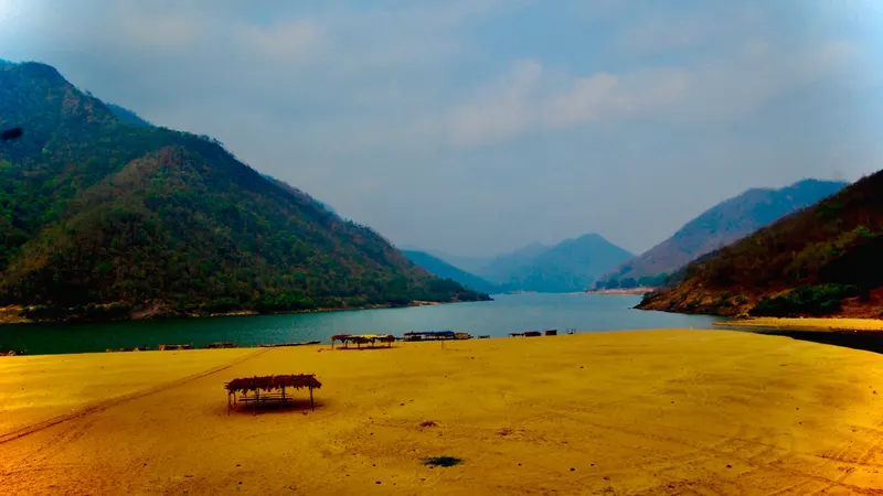The Godavari narrowing between forested hills at Papikondalu, with a sandbank in the foreground