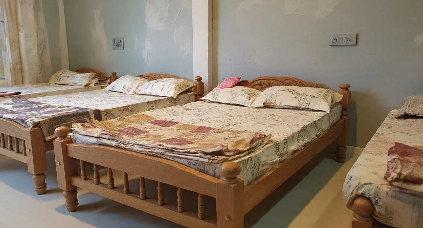 A room at Golden Hills with three wooden beds, a double and two singles, against pale blue walls with power points above the bedheads